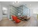 Cozy loft living area with stylish furniture, modern TV, and unique palm leaf wallpaper feature wall at 1523 Corolla Ct, Reunion, FL 34747