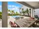 Covered patio with wood table, seating and view of backyard pool at 1523 Corolla Ct, Reunion, FL 34747
