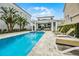 Refreshing backyard swimming pool with sun loungers, hot tub and covered patio at 1523 Corolla Ct, Reunion, FL 34747