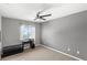 Bedroom with gray walls, ceiling fan, and window bringing in lots of natural light at 15604 Starlite St, Clermont, FL 34714