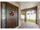 Charming front porch with brick flooring, decorative columns, and a welcoming entrance door at 15604 Starlite St, Clermont, FL 34714