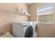 Laundry room with modern washer and dryer, plus storage shelving at 15604 Starlite St, Clermont, FL 34714