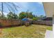 Backyard with a wood fence, some sparse grass, and a gray building in the background at 1563 Immocalee St, Intercession City, FL 33848