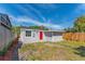 Backyard with a gray shed with a red door, wood fence, and grass at 1563 Immocalee St, Intercession City, FL 33848