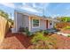 Single-story home showcasing fresh landscaping, a red door, and gray painted siding at 1563 Immocalee St, Intercession City, FL 33848