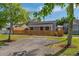 Quaint single-story home with red door, framed by a charming wooden picket fence at 1563 Immocalee St, Intercession City, FL 33848