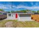 Gray shed with red door, window, and grass at 1563 Immocalee St, Intercession City, FL 33848