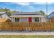 Charming single-story home featuring a vibrant red door and a quaint wooden fence at 1563 Immocalee St, Intercession City, FL 33848