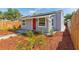 Recently landscaped single-story home featuring a red door and gray exterior at 1563 Immocalee St, Intercession City, FL 33848