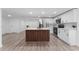 Modern white kitchen with stainless steel appliances and a striking wood-paneled island at 1563 Immocalee St, Intercession City, FL 33848