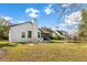 Spacious backyard featuring a patio with chairs, lush lawn and mature landscaping at 1667 Spring Loop Way, Winter Garden, FL 34787