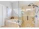 This neutral bathroom features a glass-enclosed shower, a soaking tub, and unique glass block accents at 1667 Spring Loop Way, Winter Garden, FL 34787