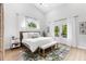 Bright bedroom featuring wood floors, a neutral rug, a wooden bed frame, and access to the backyard at 1667 Spring Loop Way, Winter Garden, FL 34787