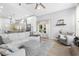 Comfortable living room features a ceiling fan, skylights, and white soft seating at 1667 Spring Loop Way, Winter Garden, FL 34787