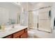 Bathroom featuring a combination shower-tub with glass door, a spacious mirror, and wooden vanity at 1730 Boat Launch Rd, Kissimmee, FL 34746