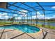 Sparkling screened-in pool and attached spa overlooking a tranquil waterfront view with lush landscaping at 1730 Boat Launch Rd, Kissimmee, FL 34746