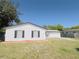 View of a white single story house with black shutters and a well-maintained lawn at 1762 Philadelphia Ct, Deltona, FL 32725