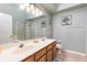 Bathroom with double sinks, large mirrors, walk-in shower, and neutral paint at 2109 Carpathian Dr, Apopka, FL 32712