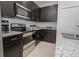 A modern kitchen features dark cabinets, stainless steel appliances, and granite countertops at 2681 Sw 161St Loop, Ocala, FL 34473