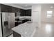 A modern kitchen features dark cabinets, stainless steel appliances, and granite countertops at 2681 Sw 161St Loop, Ocala, FL 34473