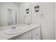 Bathroom with double vanity sinks, large mirror, and decorated with tasteful wall decor at 2736 Dumont Ln, Tavares, FL 32778