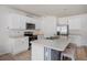 Modern kitchen showcasing stainless steel appliances, white cabinets, and a center island with breakfast bar at 2736 Dumont Ln, Tavares, FL 32778