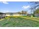 Large, green backyard with a white fence and colorful chairs, perfect for outdoor activities at 295 Garland St, Deltona, FL 32725