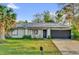 Charming single-story home with solar panels, a well-manicured lawn, and a two-car garage at 295 Garland St, Deltona, FL 32725