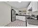 Well-lit kitchen featuring granite countertops, stainless steel appliances, and tile flooring at 295 Garland St, Deltona, FL 32725