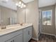 Bright bathroom with double sinks, a framed mirror, and glass shower door and a window at 31807 Broadwater Ave, Leesburg, FL 34748