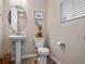 Elegant powder room featuring a pedestal sink, decorative mirror, and stylish fixtures at 31807 Broadwater Ave, Leesburg, FL 34748