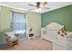 Cozy Bedroom features a rocking chair, a white crib, and ample space for play at 31807 Broadwater Ave, Leesburg, FL 34748