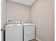 Functional laundry room with a washer and dryer set against a neutral wall at 31807 Broadwater Ave, Leesburg, FL 34748