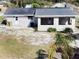 The backyard and rear exterior shows the white door and sunroom area, with a palm tree in view at 32803 Forest Ave, Leesburg, FL 34788