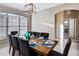 Dining room with seating for eight featuring modern light fixture and sunlit window at 334 Prestwick Dr, Davenport, FL 33897