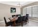 Bright dining room with a table set for eight, modern lighting, and a golf-themed wall art at 334 Prestwick Dr, Davenport, FL 33897