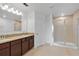 Bathroom featuring a double sink vanity with granite countertops, a shower, and tile flooring at 520 Pinecrest Loop, Davenport, FL 33837