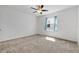 Bright bedroom featuring neutral carpet, ceiling fan, and a window with blue curtains at 520 Pinecrest Loop, Davenport, FL 33837