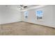 Spacious main bedroom with neutral carpet, a ceiling fan, and two windows for natural light at 520 Pinecrest Loop, Davenport, FL 33837