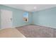 A bright, empty bedroom with neutral carpet and light blue walls showcases a window and tiled entryway at 520 Pinecrest Loop, Davenport, FL 33837