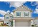 Two-story home featuring a two-car garage, well-maintained lawn, and tasteful green shutter accents at 520 Pinecrest Loop, Davenport, FL 33837