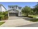 Charming two-story home with stone accents, a two-car garage, and a nicely paved driveway at 7641 Fairfax Dr, Kissimmee, FL 34747