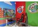 Fun game room with Mario themed walls, a TV, glass table, and ergonomic gaming chairs at 7641 Fairfax Dr, Kissimmee, FL 34747