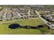 Aerial view of a neighborhood featuring homes, green space with a pond and tree lined streets at 846 Asturias Rd, Davenport, FL 33837