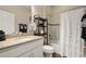 Well-lit bathroom features a vanity with granite countertops, a shower-tub combo, and decorative elements at 846 Asturias Rd, Davenport, FL 33837