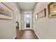 Hallway with wood floors features decorative wall art and a decorative glass front door at 846 Asturias Rd, Davenport, FL 33837