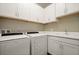 Laundry room features modern appliances, lots of white cabinets, tile backsplash and a sink at 846 Asturias Rd, Davenport, FL 33837