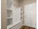 Mudroom with a built-in storage bench, white shelving, coat hooks, and a white door at 846 Asturias Rd, Davenport, FL 33837