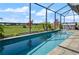 Inviting screened-in pool with serene views and well manicured landscaping in the background at 846 Asturias Rd, Davenport, FL 33837