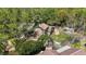 Aerial view of a home with a brown roof, surrounded by mature trees and a green lawn at 9939 Triple Crown Cir, Orlando, FL 32825